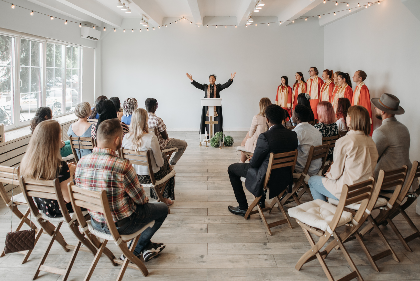 Pastor at the Podium with Her Arms Raised